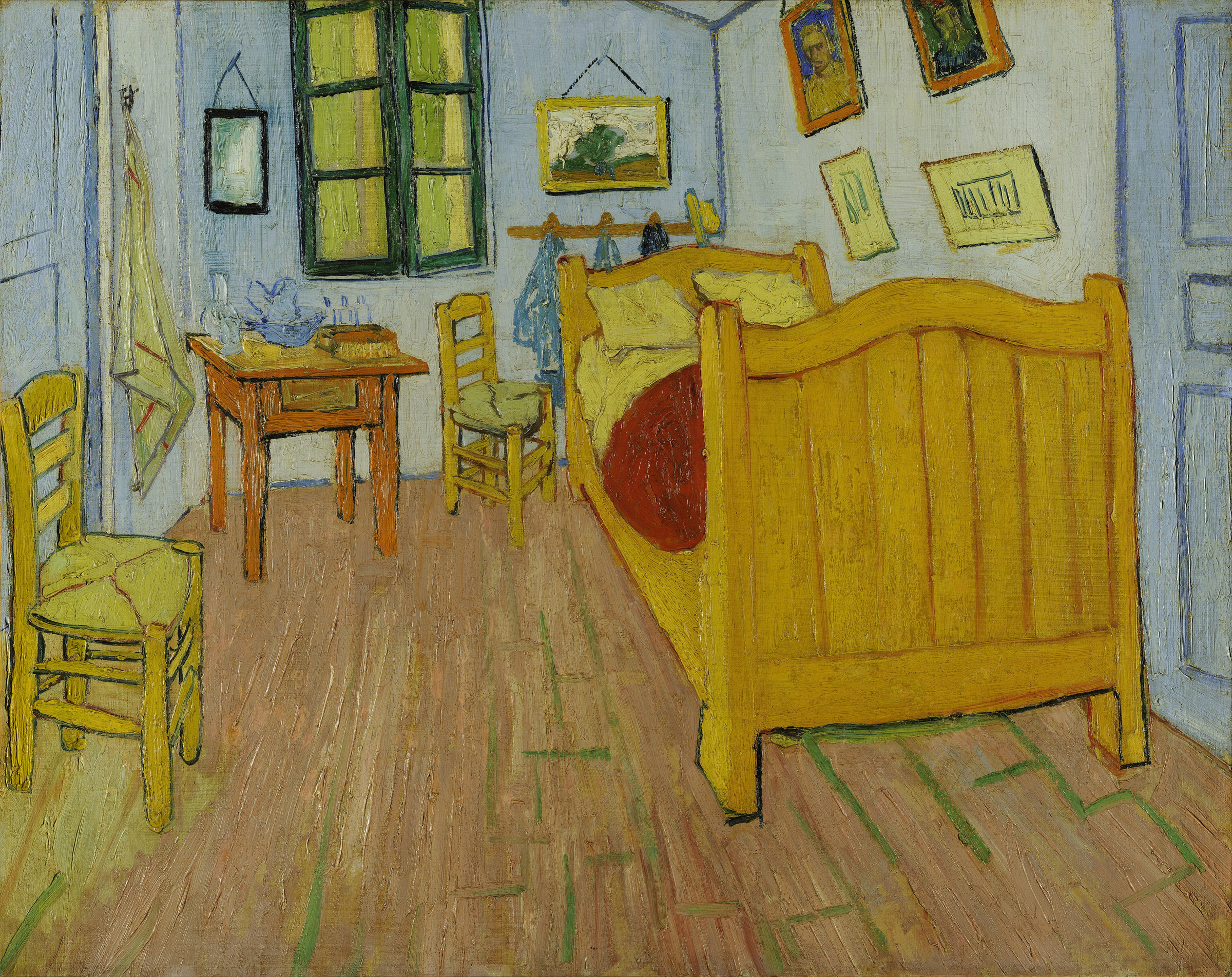 Vincent van Gogh’s 1888 Bedroom, with a bright bed, two chairs, a small table, pictures, and strongly colored walls.